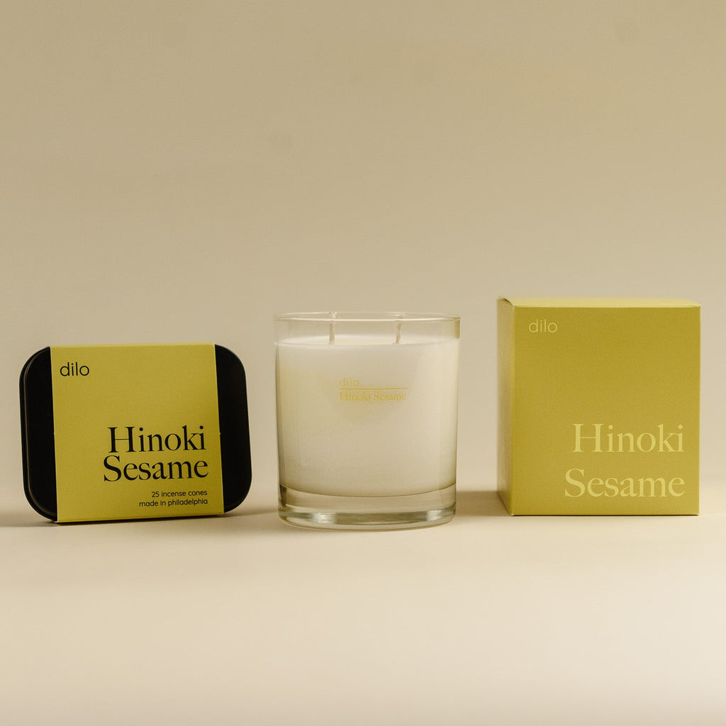 Hinoki Sesame candle with packaging on a beige background